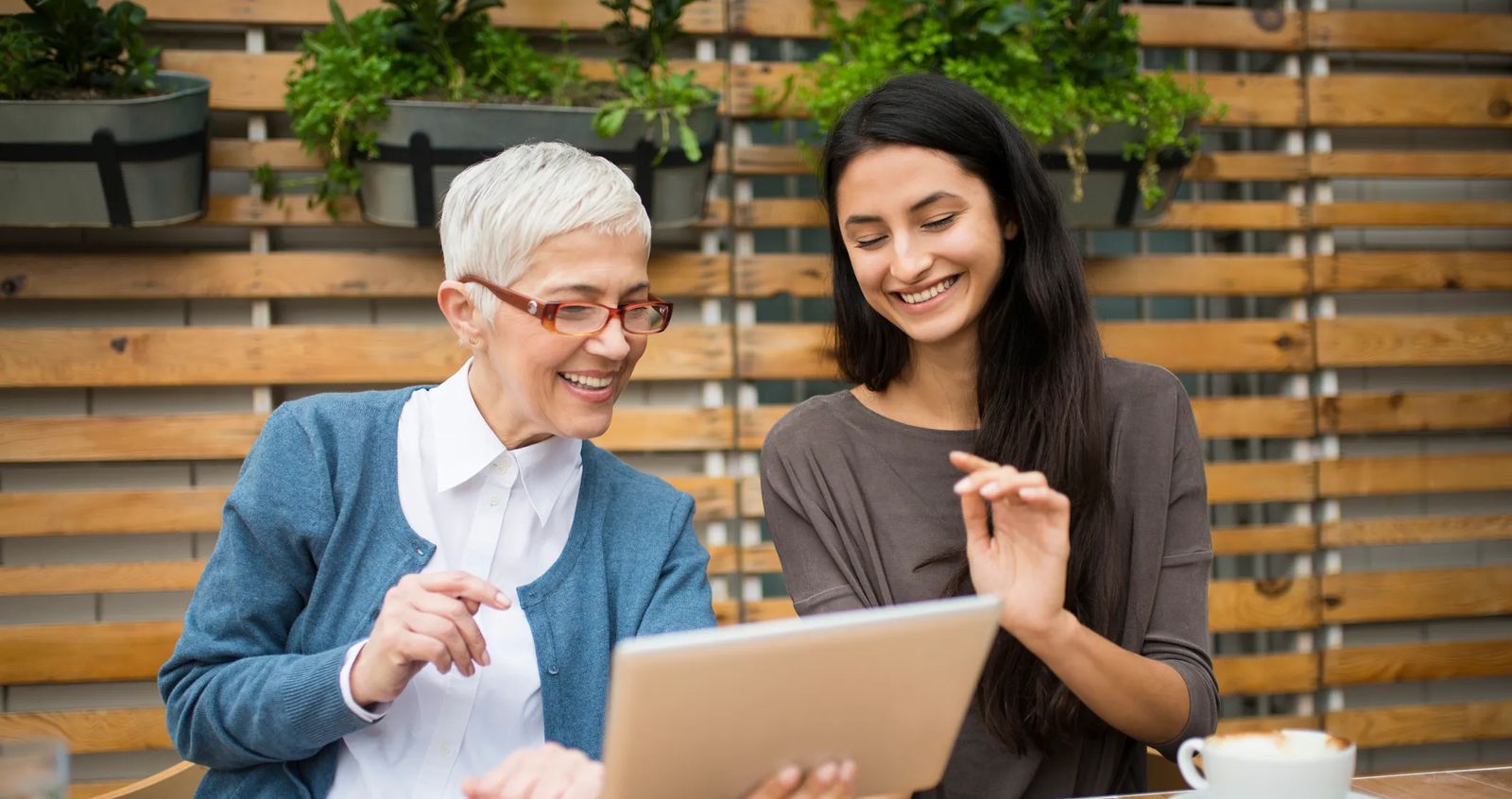 Free business mentorship programs. Image of woman mentoring younger female aspiring entrepreneur.